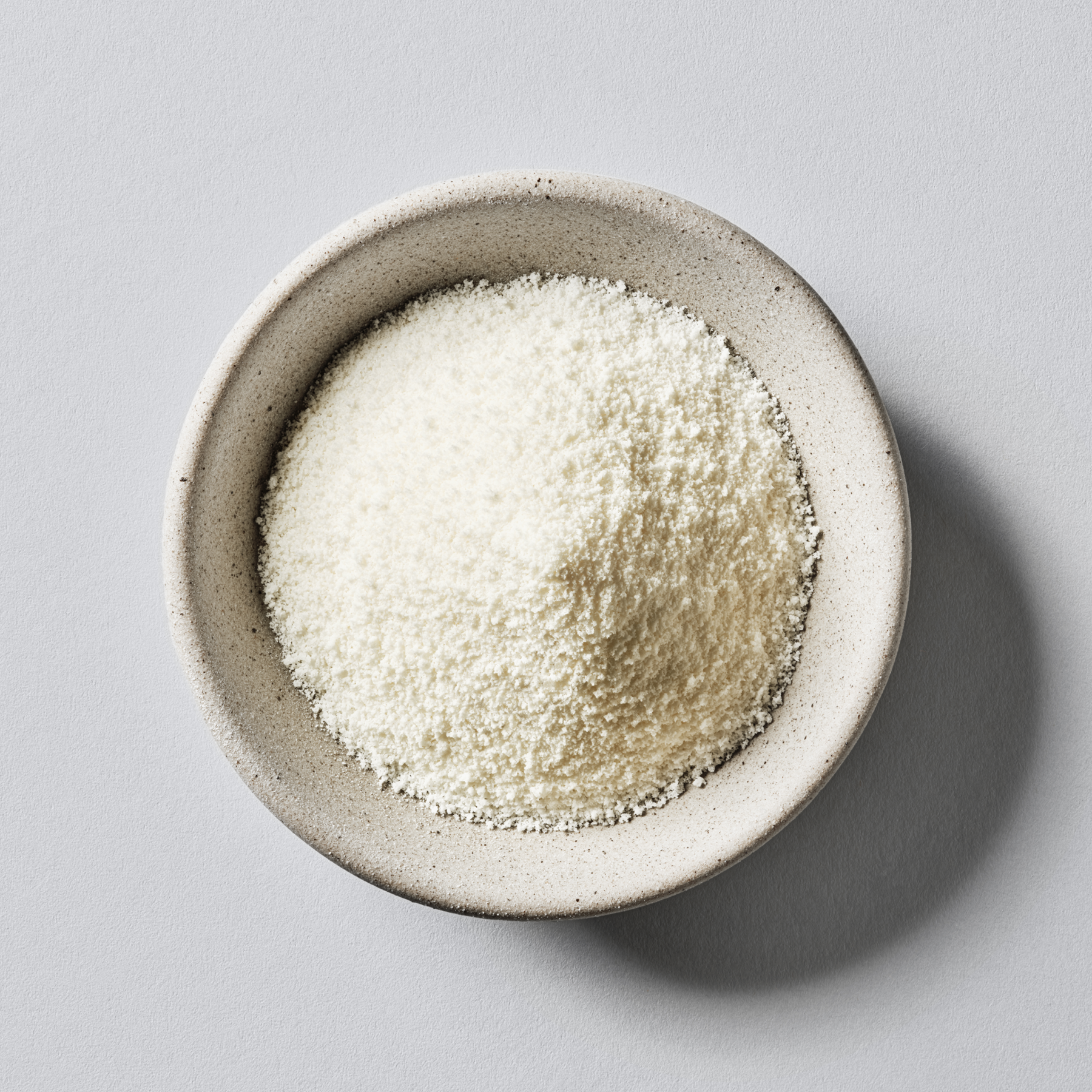 A small ceramic bowl of Sports Research Marine Collagen Peptides powder.