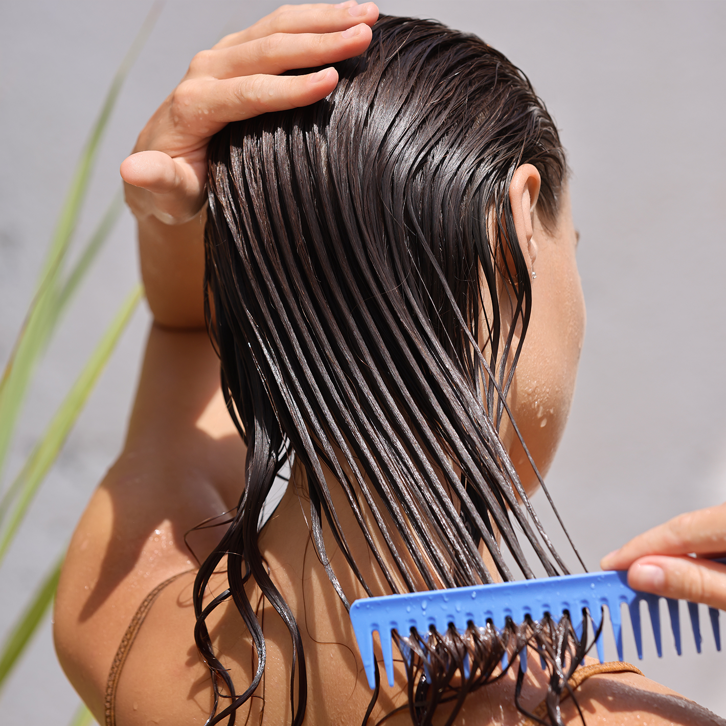 A woman combing her wet hair.